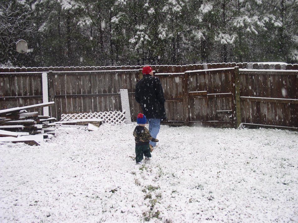 father with a child in a snowy yard