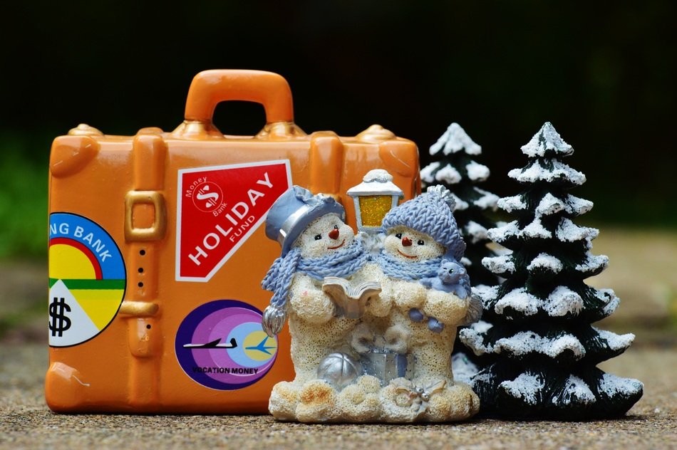 figurines of snowmen and Christmas trees and orange suitcase