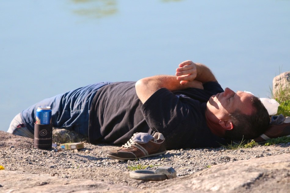 man lies on the river bank