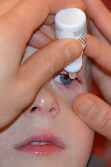 mom dripping eye drops to the baby