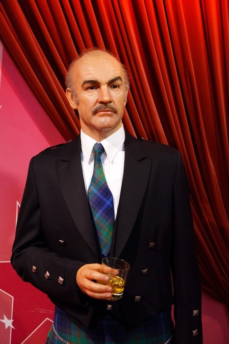 Portrait of James Bond near the red curtains