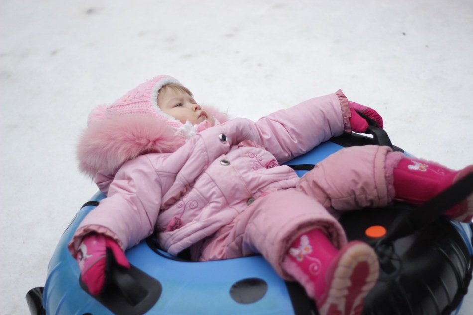 child on a rubber circle in the snow