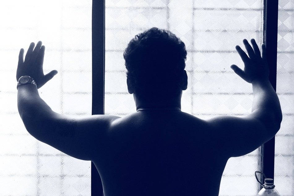 rear view of a topless man near the window