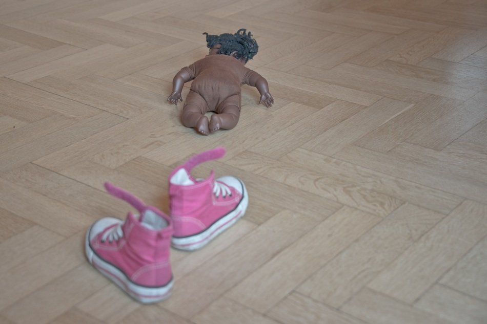 doll on the floor near the girls shoes