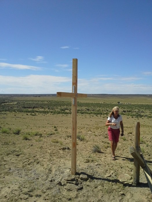 lonely woman near the cross on a sunny day
