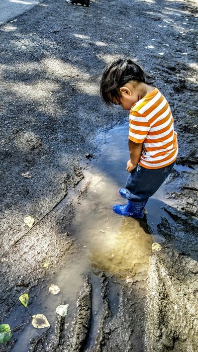 child explores the earth on the street