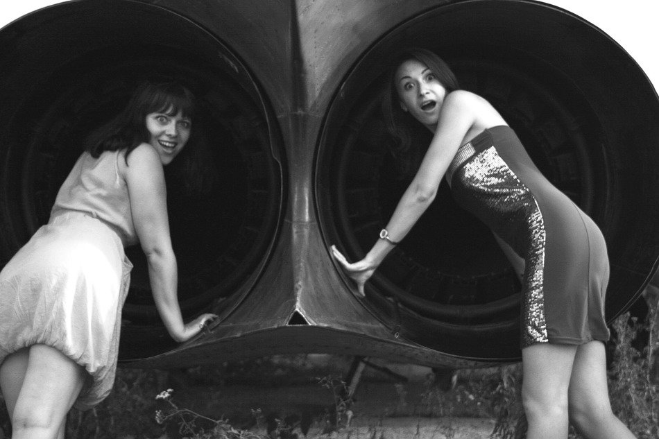 Black and white image of girls near the airplane