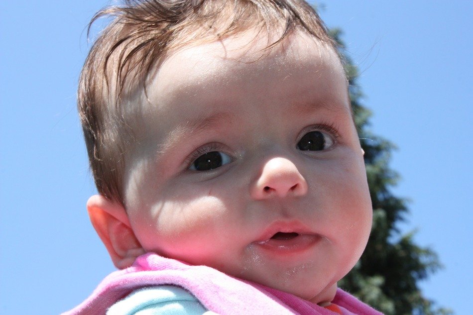 adorable baby against the sky on a sunny day