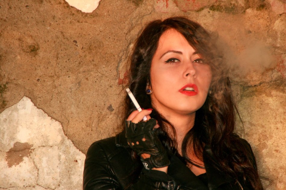 dark-haired girl in a leather jacket with a cigarette in her hand