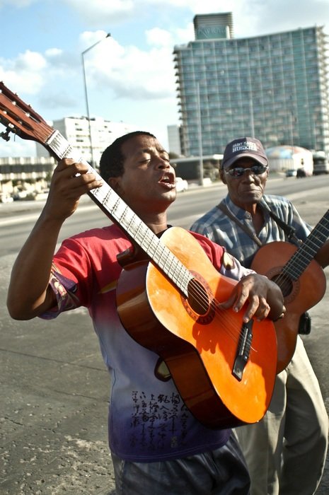 Street musicians with guitars on the cube