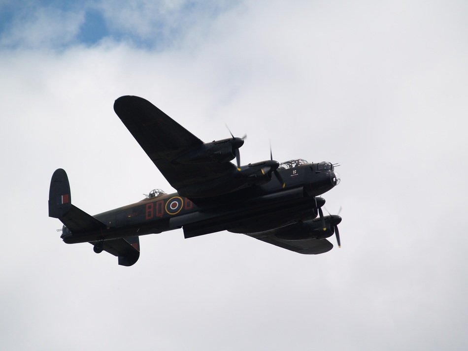 bomber flies under the clouds