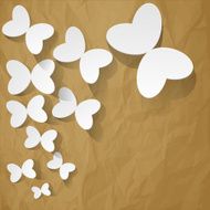 White paper butterflies on a crumpled brown background
