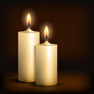 Two burning candles on black background