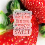 Quote typographical label on realistic blurred background of ripe strawberries