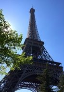 View from below of the Eiffel Tower in the glare of the sun