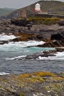 lighthouse stands on a rocky mountain