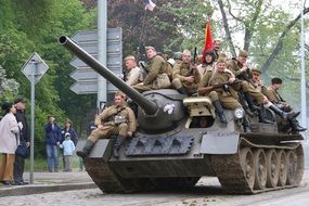 Soldiers with a red flag on a tank at the military-historical parade in Prague