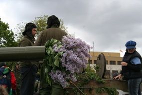 Soldiers on a tank with lilac flowers at the parade in Prague