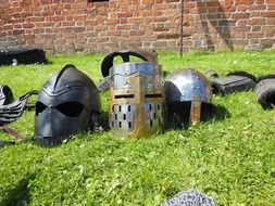 variety of knightly helmets on green grass