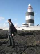 man near lighthouse in ireland