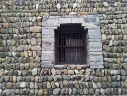 barred window in an old stone house