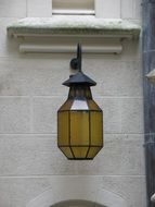 yellow lamp on the wall of a building on the street