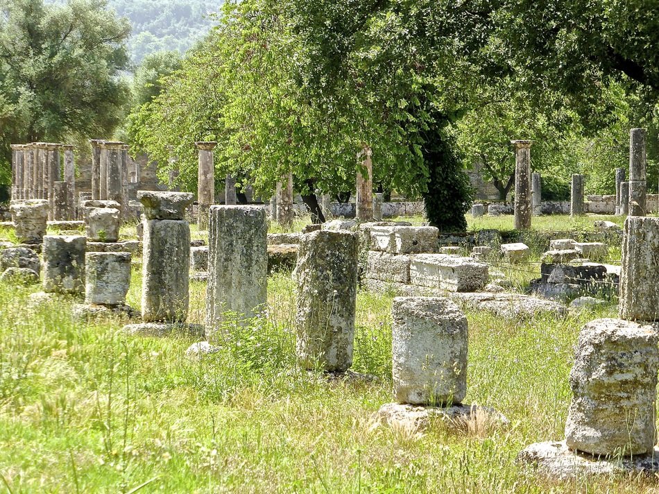 ruins of columns in a green meadow