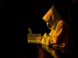 monk is reading a book in the dark