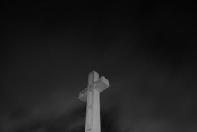 monochrome picture of white cross against the night sky