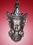 pewter buddha ornament on red background