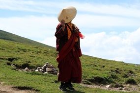 person in traditional asian clothing stands on hillside