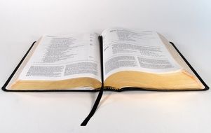 An open bible on a white surface