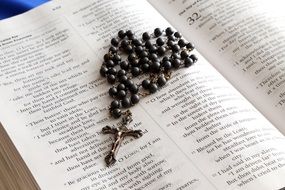 rosary cross on the Bible book