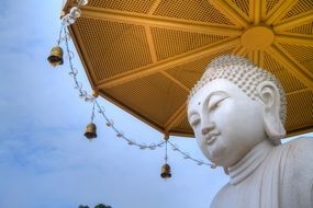 buddha, white statue beneath golden parasol