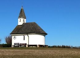 a chapel with white walls on a hill