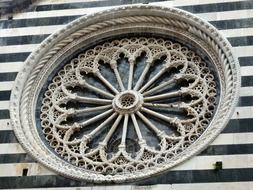 window with reliefs on the facade of a church in italy