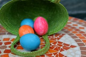 colorful eggs in green basket