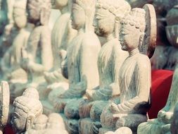 white Buddha sculptures in front of a temple in Thailand