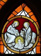 stained glass window of church with illustration of Jesus crib