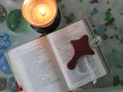cross on prayer book and candle
