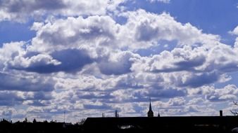 spire of the cathedral against the background of cumulus clouds