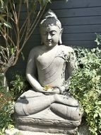 buddha statue among green bushes