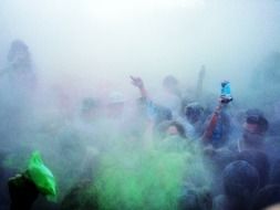 people in blue smoke at festival of colours