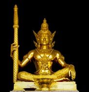 golden deity statue on a dark background