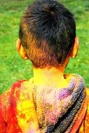 child boy painted in indian holi colors