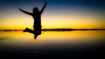 photo of a girl jumping in the sunset
