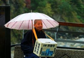 monk with pink umbrella in taiwan