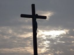 crucifixion of Christ on the cross against a cloudy sky