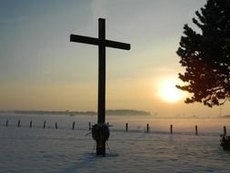 cross on the sidewalk at sunset