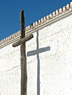 wooden cross at the stone wall